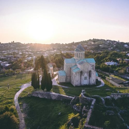 الرئيسية Aerial view of Bagrati Cathedral in Kutaisi, Georgia, showcasing stunning landscape at sunrise.